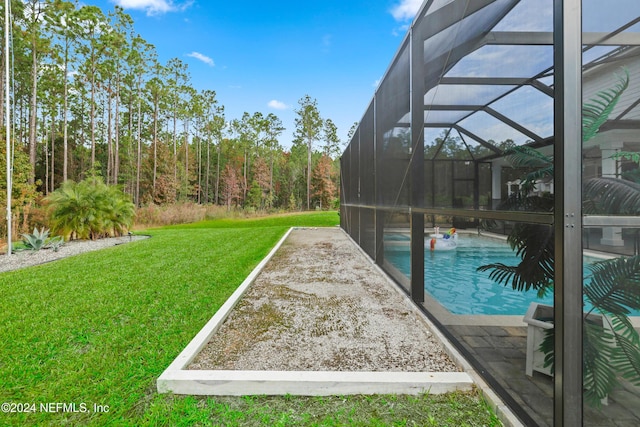 view of swimming pool featuring a lawn, a patio area, and a lanai