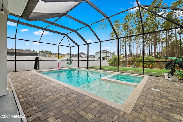 view of swimming pool featuring glass enclosure, an in ground hot tub, and a patio