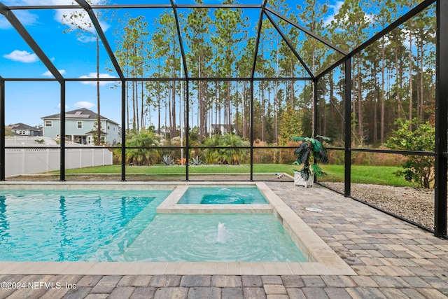 view of pool with a lanai, a patio area, and an in ground hot tub