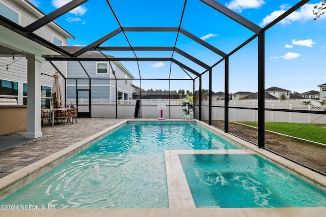 view of swimming pool featuring glass enclosure and a patio area