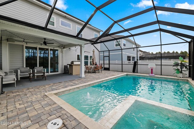 view of swimming pool with a lanai, outdoor lounge area, ceiling fan, and a patio