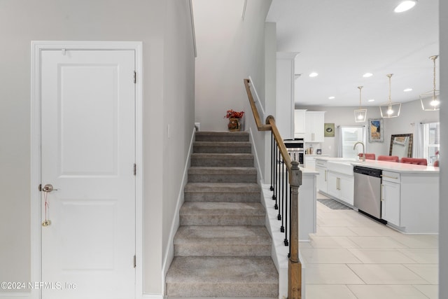 stairway with tile patterned floors and sink