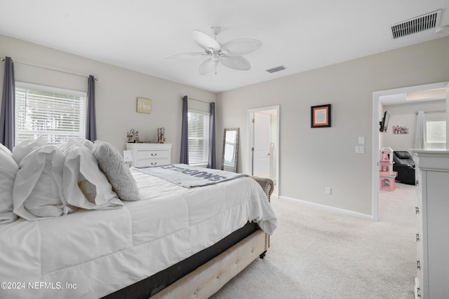 bedroom featuring multiple windows, ceiling fan, and light carpet