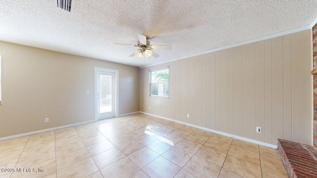 spare room featuring ceiling fan, light tile patterned floors, a textured ceiling, and visible vents