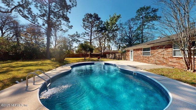 outdoor pool with a lawn, a patio area, and fence