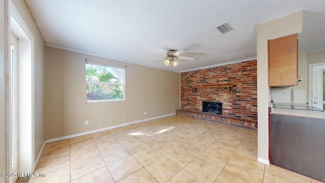 unfurnished living room featuring ornamental molding, a brick fireplace, visible vents, and light tile patterned floors