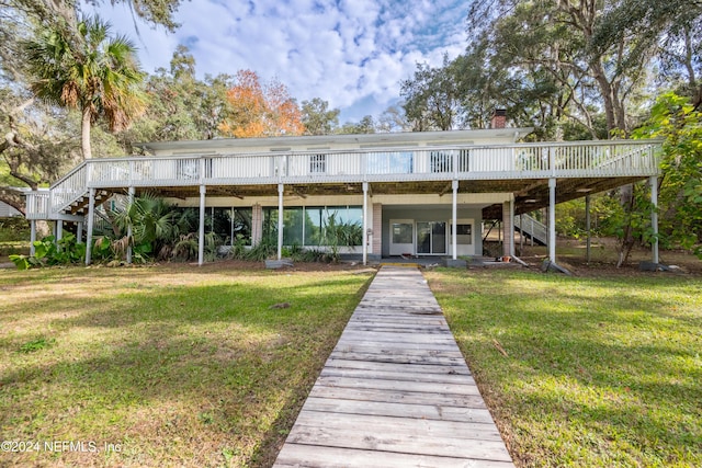 back of property with a yard and a wooden deck