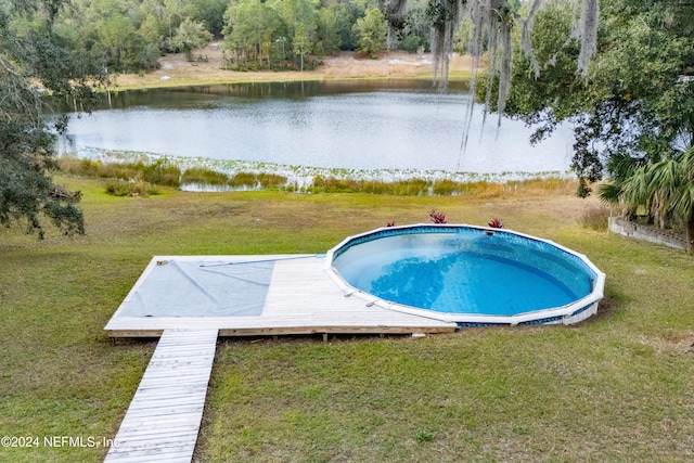 view of swimming pool featuring a yard and a water view