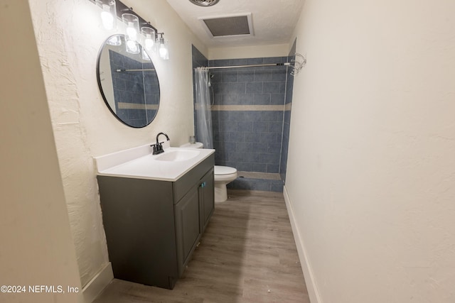 bathroom with a shower with curtain, hardwood / wood-style floors, vanity, and toilet