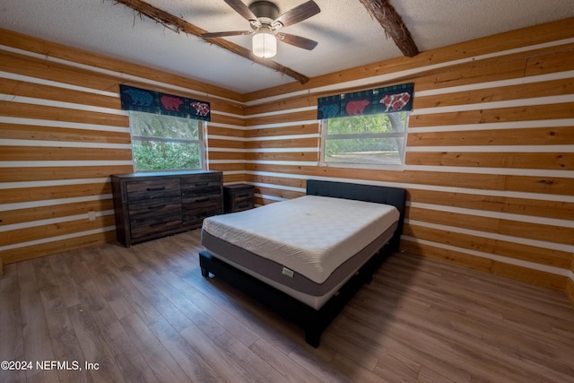 bedroom with ceiling fan, hardwood / wood-style floors, and a textured ceiling