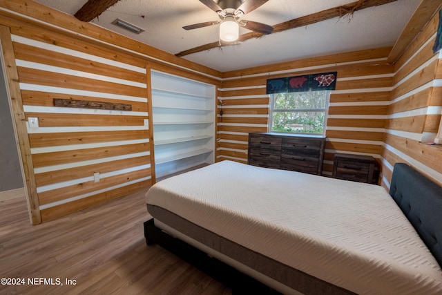 bedroom featuring ceiling fan, hardwood / wood-style floors, and a textured ceiling