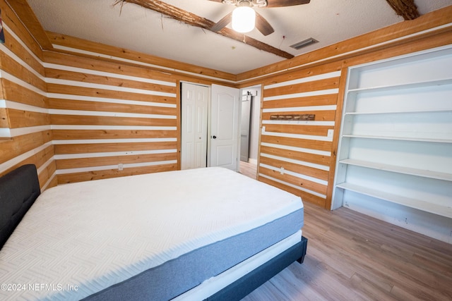 bedroom featuring hardwood / wood-style flooring, ceiling fan, and a textured ceiling