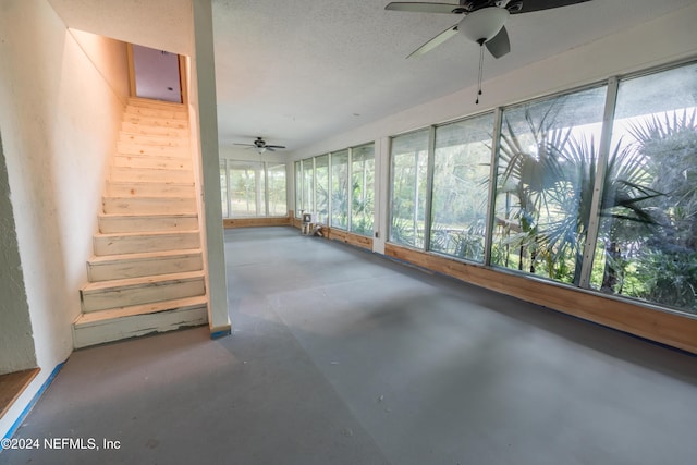 unfurnished sunroom featuring ceiling fan