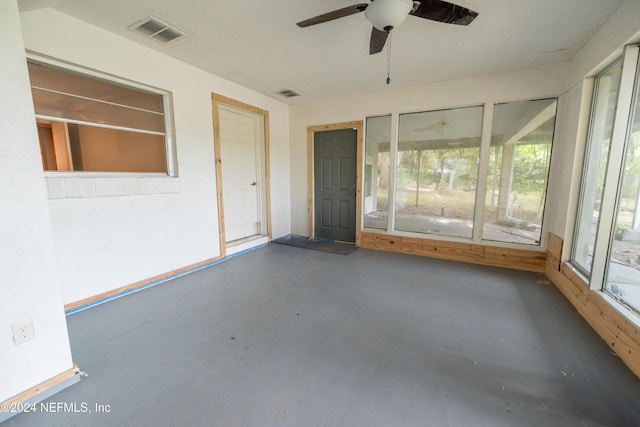 unfurnished sunroom featuring ceiling fan