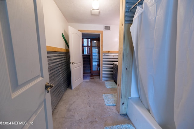 bathroom featuring shower / tub combo and concrete floors