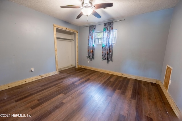 unfurnished bedroom with ceiling fan, dark hardwood / wood-style flooring, a textured ceiling, and a closet