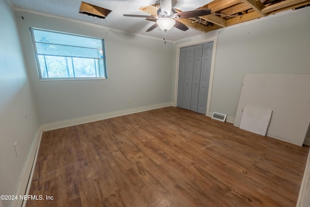 unfurnished bedroom with hardwood / wood-style floors, ceiling fan, and a closet