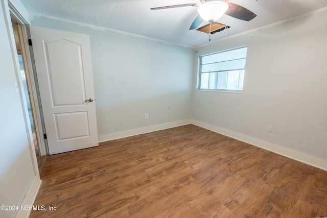 empty room with hardwood / wood-style flooring, ceiling fan, and a textured ceiling