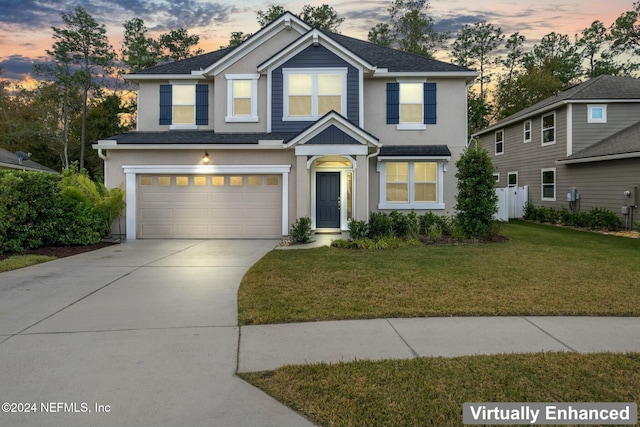 view of front facade with a garage and a yard