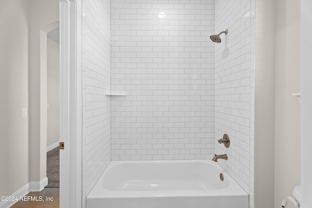 bathroom featuring tile patterned flooring and tiled shower / bath