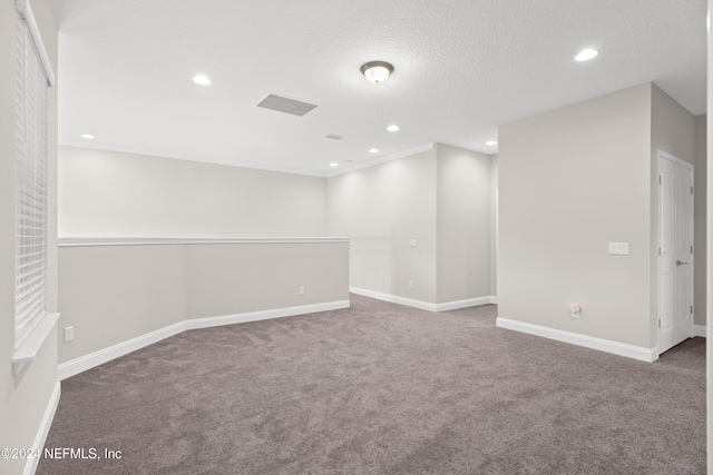 unfurnished room featuring carpet and a textured ceiling