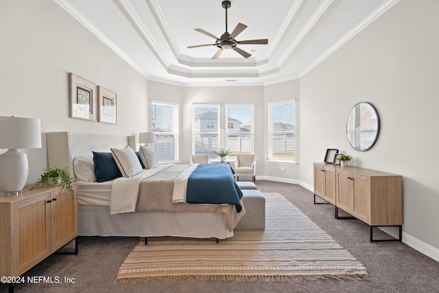 bedroom featuring dark colored carpet, ceiling fan, crown molding, and a tray ceiling