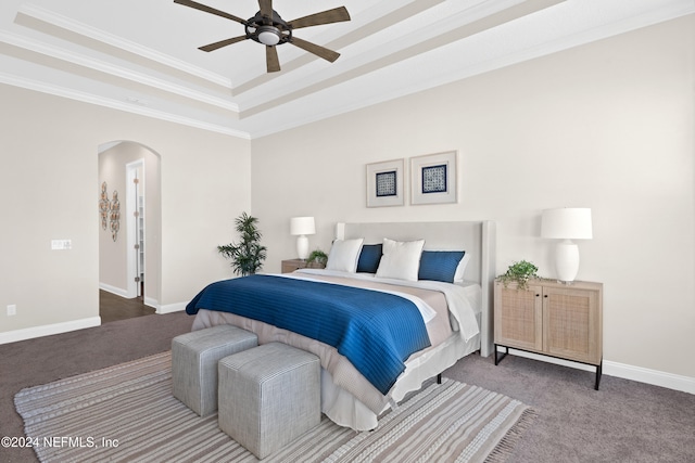 carpeted bedroom featuring a raised ceiling, ceiling fan, and ornamental molding