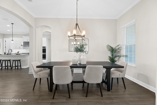 dining space with a chandelier, dark hardwood / wood-style flooring, crown molding, and sink