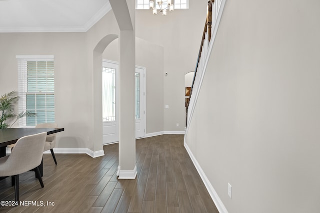 entrance foyer with a notable chandelier, dark hardwood / wood-style floors, and crown molding