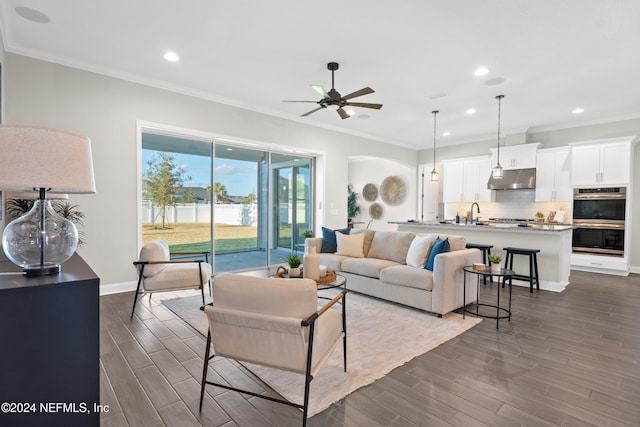 living room featuring ceiling fan, dark hardwood / wood-style flooring, and crown molding