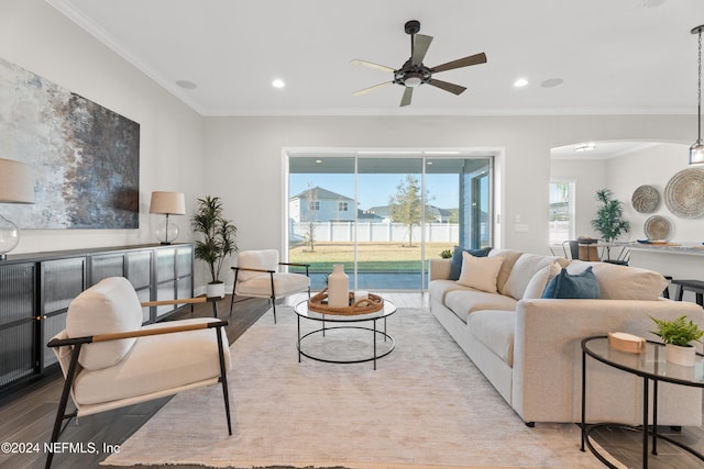 living room with crown molding, ceiling fan, and light hardwood / wood-style floors