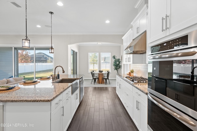 kitchen with a center island with sink, white cabinetry, and appliances with stainless steel finishes