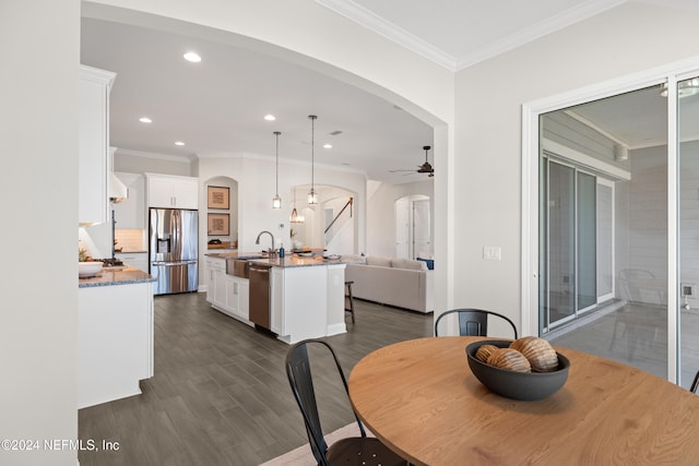 dining room with dark hardwood / wood-style floors, ceiling fan, ornamental molding, and sink