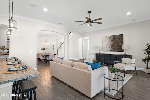 living room featuring crown molding, ceiling fan with notable chandelier, and dark hardwood / wood-style floors