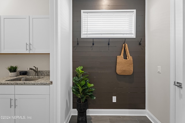 mudroom with dark tile patterned flooring and sink