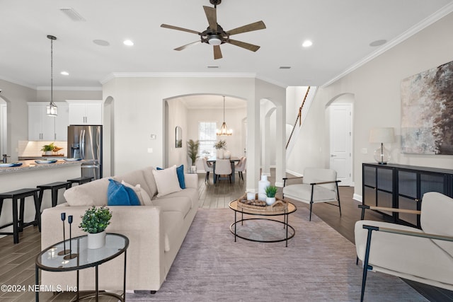 living room with ceiling fan with notable chandelier, hardwood / wood-style flooring, and ornamental molding