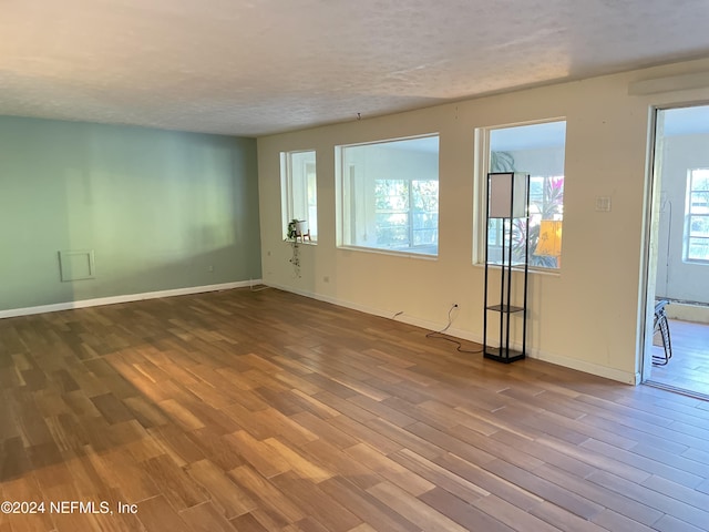 empty room with a textured ceiling and hardwood / wood-style flooring