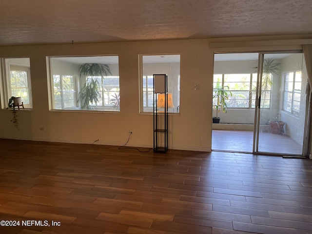 empty room featuring dark wood-type flooring and a textured ceiling