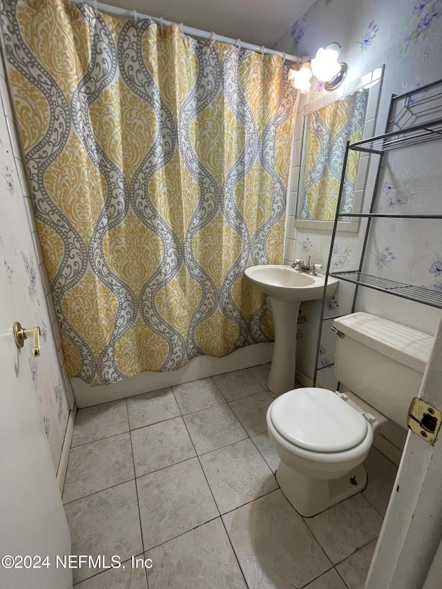 bathroom featuring tile patterned flooring, a shower with curtain, toilet, and sink