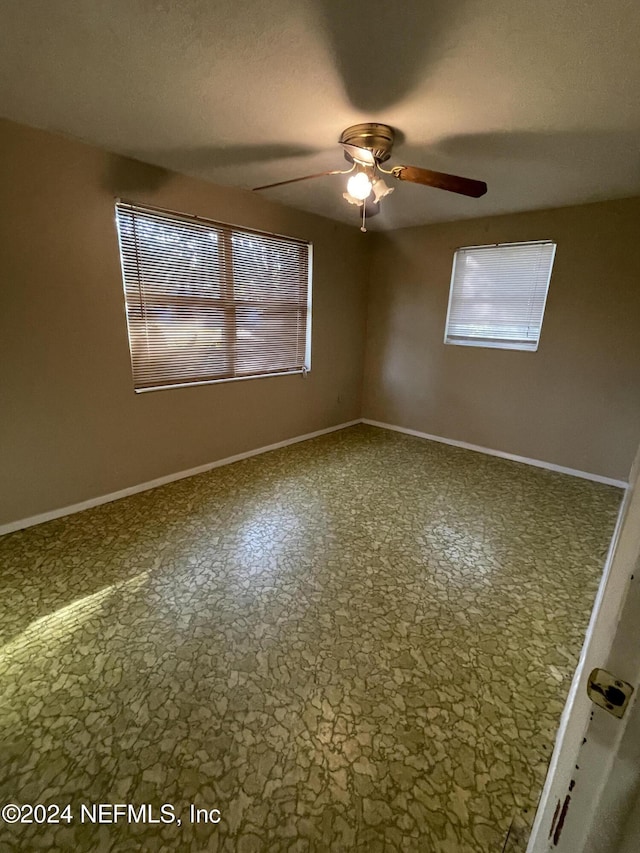 unfurnished room featuring ceiling fan and a textured ceiling