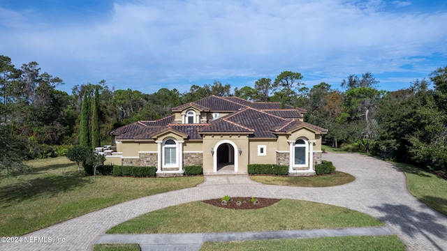 mediterranean / spanish home with a front yard