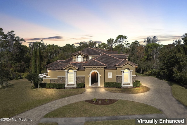 mediterranean / spanish-style home with a lawn