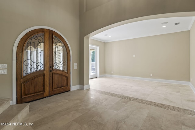 entrance foyer with french doors and crown molding