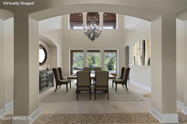 dining room with a towering ceiling and an inviting chandelier