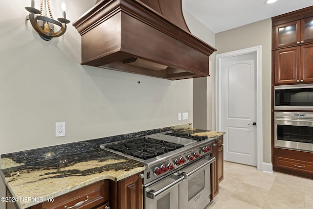 kitchen with premium range hood, light stone counters, light tile patterned flooring, and stainless steel appliances