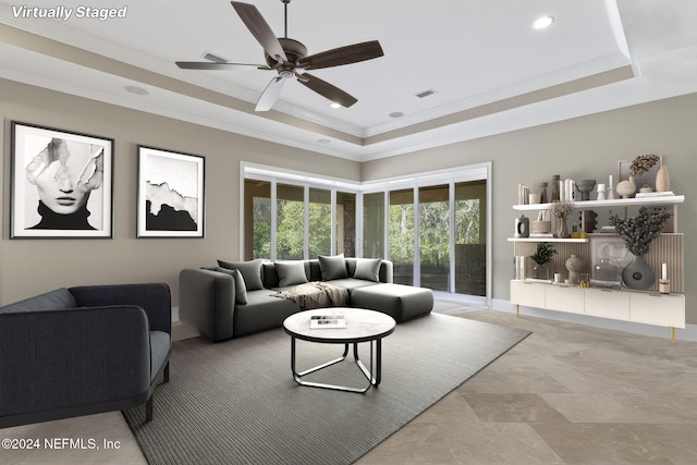 living room featuring a tray ceiling, ceiling fan, and ornamental molding