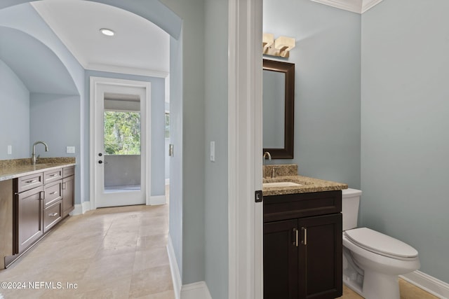 bathroom featuring tile patterned flooring, vanity, toilet, and crown molding