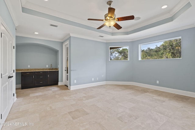 unfurnished bedroom featuring a raised ceiling, crown molding, and ceiling fan