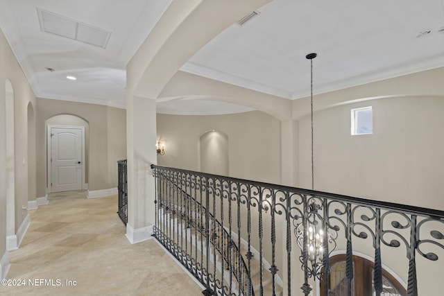 hall with a notable chandelier and ornamental molding