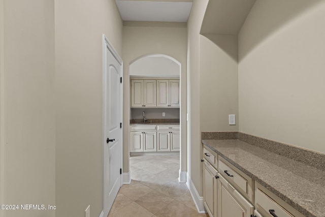 hallway featuring light tile patterned floors and sink